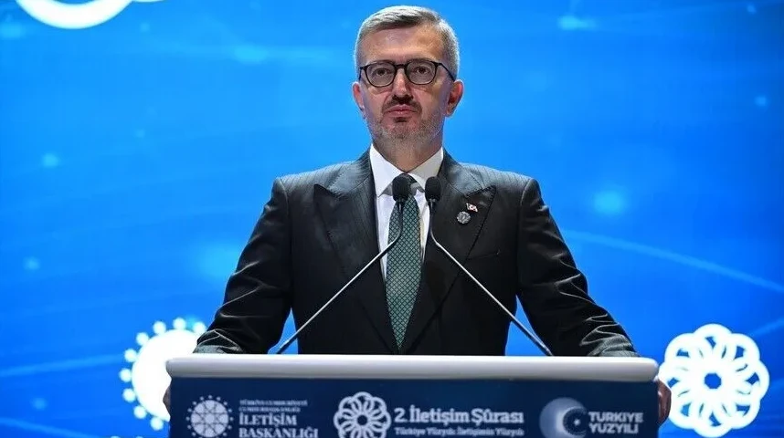 Političar u crnom odijelu sa zelenom kravatom iza podijuma