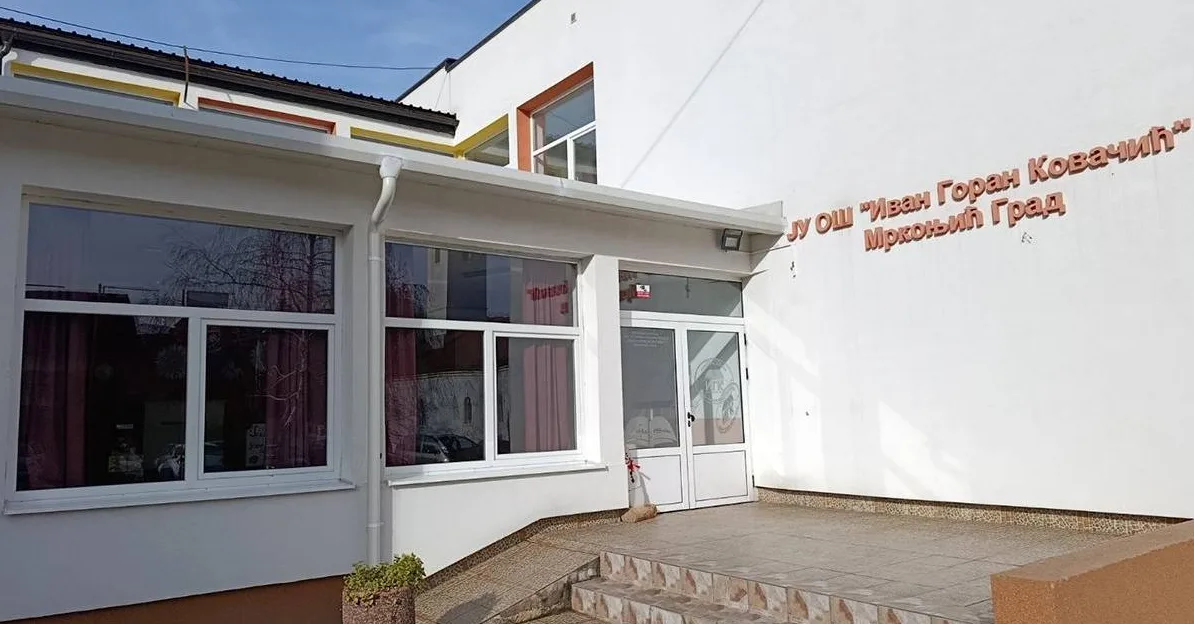 Ulaz u Osnovnu školu "Ivan Goran Kovačić" u Mrkonjić Gradu sa natpisom na fasadi.