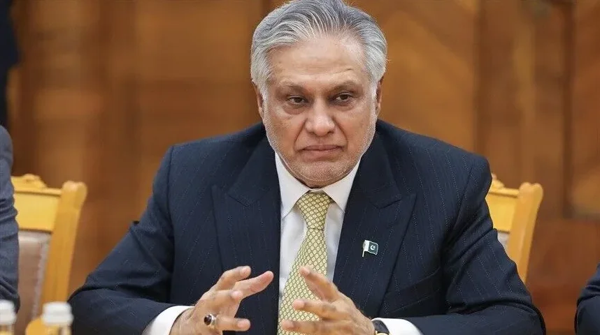 Portret Isaka Dara, pakistanskog ministra finansija, koji sjedi za stolom u tamnom odijelu i svijetloj kravati, sa zastavicom Pakistana na reveru.