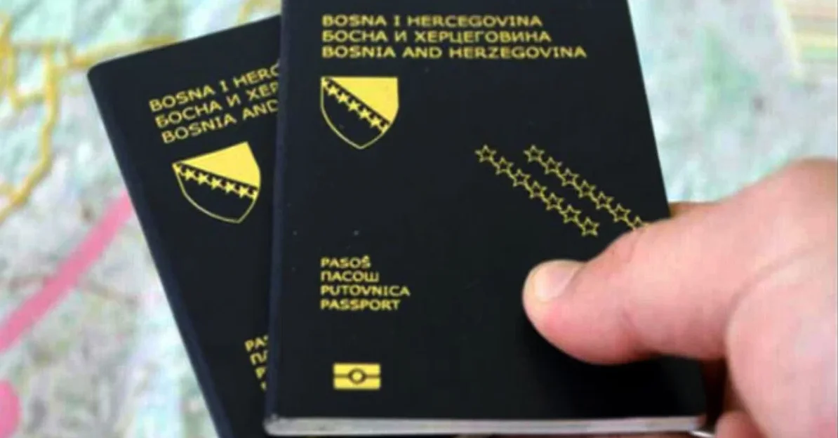 Dvije crne putovnice Bosne i Hercegovine leže na podlozi nalik na kartu, a jedna je u ruci.