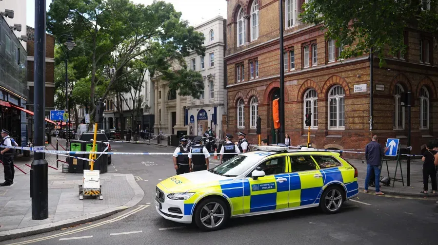 Policijski službenici i vozilo metropolitske policije na ulici u Londonu sa trakom za obilježavanje.