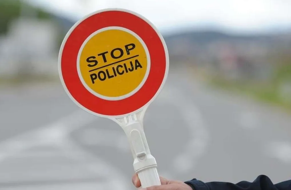 Saobraćajni znak 'STOP POLICIJA' koji drži policajac