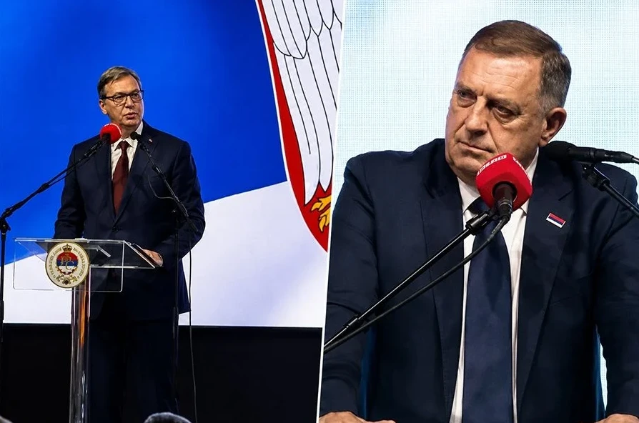 Aleksandar Vučić govori za govornicom pored zastave, dok je Milorad Dodik u drugom planu s mikrofonom.