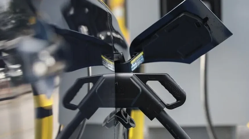 Detalj punjača za električni automobil sa otvorenim poklopcem.