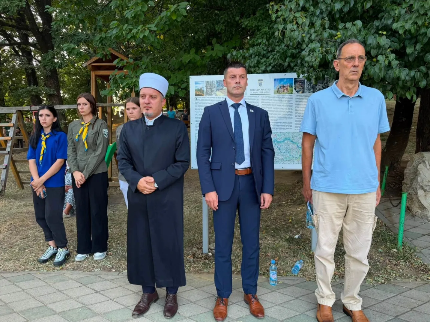 Grupa ljudi na ceremoniji na Visu, uključujući vjerskog službenika, izviđače i zvaničnike.