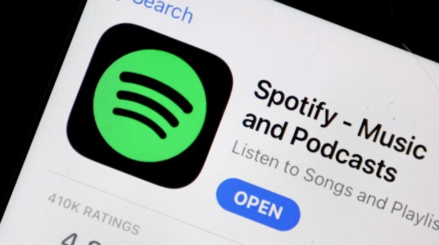 Ikona aplikacije Spotify sa zelenim logom na crnoj pozadini, prikazana na ekranu telefona.