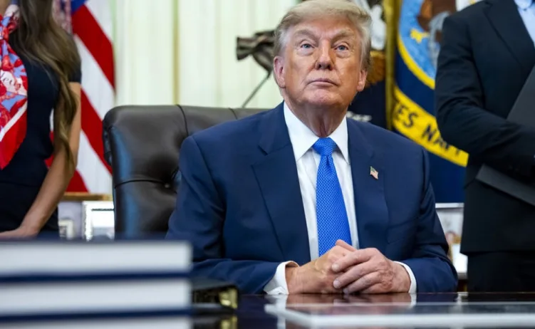 Donald Trump sjedi u Ovalnom uredu.