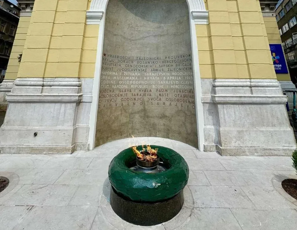 Vječni plamen postavljen na zelenom postolju ispred spomen-ploče u Sarajevu.