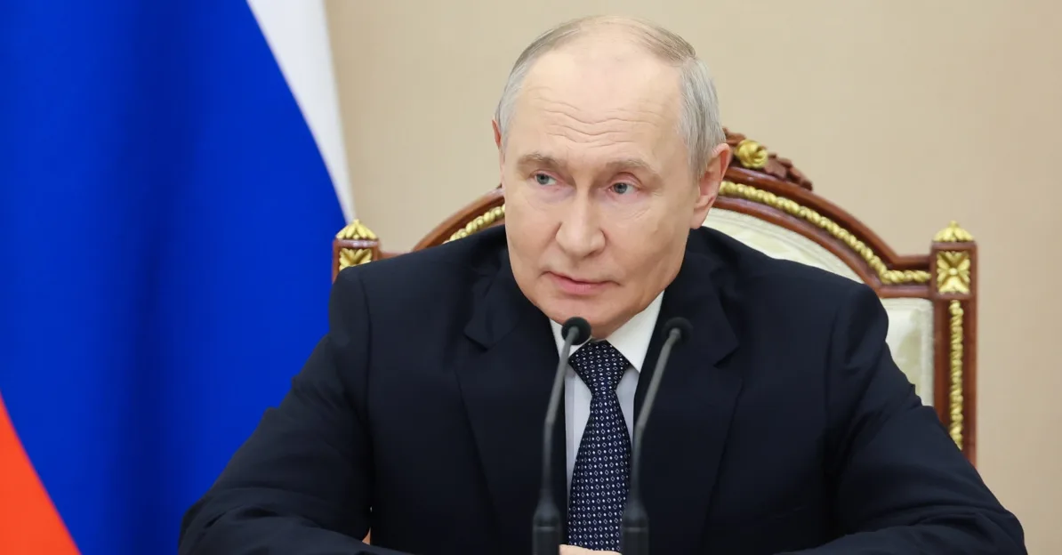 Vladimir Putin sjedi u stolici ispred zastave Rusije