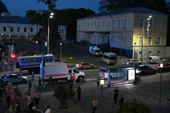 Više vozila hitne pomoći i policijska vozila parkirana su na ulici tokom večeri.